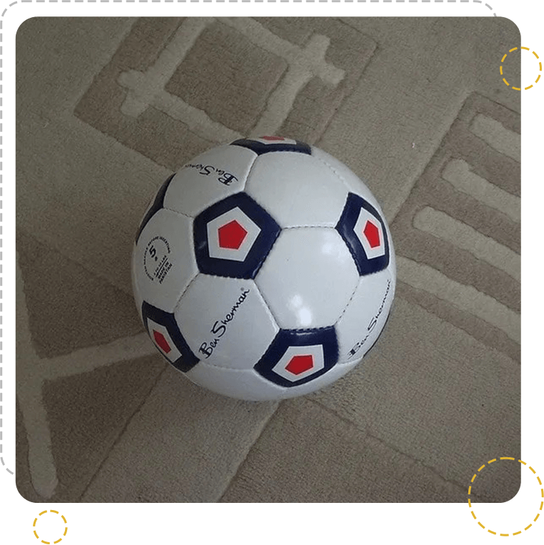 A soccer ball is on the ground with a large cross.
