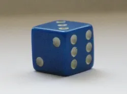 A blue dice with six dots on it.