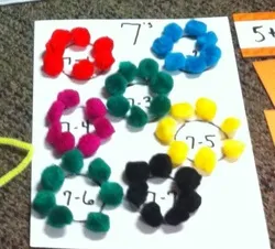 A number of different colored pom poms on paper
