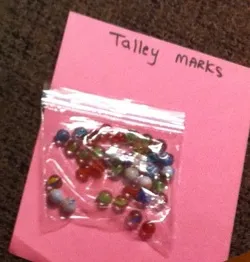 A pink paper with some colorful beads in it